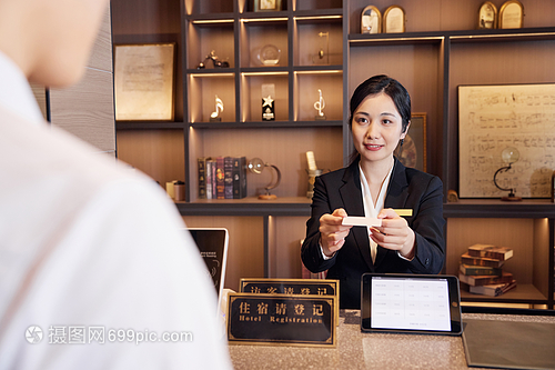 酒店前臺女服務(wù)員遞上房卡